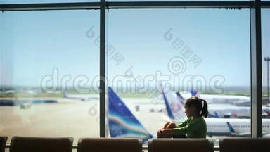 儿童在机场窗口附近看飞机，等待飞行时间
